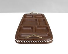 a chocolate bar shaped like a purse sitting on top of a white table with chain around it