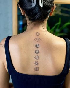 the back of a woman's neck with seven chakras tattooed on it