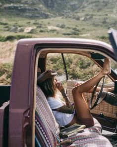 a woman sitting in the driver's seat of a truck talking on her phone