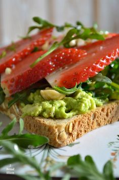 a sandwich with strawberries and avocado on it