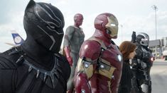 several people dressed up as iron man and black widow standing in front of an airport