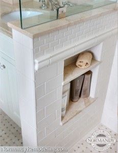 a bathroom with a sink, mirror and white brick fireplace in the middle of it