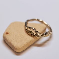 two gold rings sitting on top of a rock