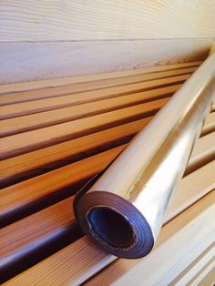 a rolled up piece of wood sitting on top of a wooden slatted floor