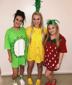 three girls dressed up as fruit and pineapples for the halloween costume contest, standing next to each other