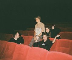 some people are sitting in the middle of a red chair and posing for a photo