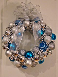 a blue and silver christmas ornament wreath hanging on a door