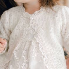 Handmade in the USA The Penelope Knit Sweater is a wonderful addition to your Penelope outfit. Made of 100% knit in ivory. Venice lace trim with floral embroidered lace and pearl style buttons. The bonnet also features Venice lace trim all the way around the edge. Soft elastic stretches for a comfortable fit for baby. Ivory silk ribbon ties are a beautiful extra touch. So special and pretty, perfect to keep her warm and it will look gorgeous with any outfit. 100% knit acrylic in ivory Venice lac Fall White Lace Top, Fitted Long Sleeve Sweater With Lace Trim, Elegant Fitted Cardigan With Lace Trim, Elegant Fitted Lace Trim Cardigan, Elegant Winter Cardigan With Lace Trim, Elegant Long Sleeve Cardigan With Lace Trim, Elegant Long Sleeve Lace Trim Cardigan, Fitted Lace Cardigan With Crochet Details, Fitted Lace Cardigan With Crochet Lace