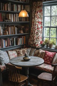 a room with bookshelves full of books and a table in the corner next to two chairs