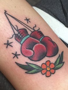 a tattoo with boxing gloves and flowers on it