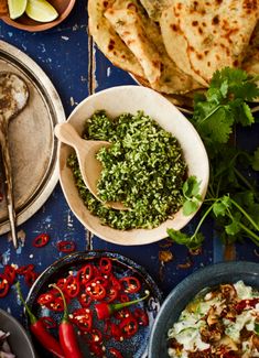 an assortment of food on a table including pita bread, salsa, and tortillas