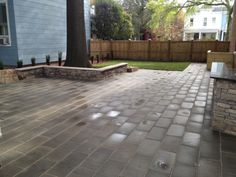 a brick patio in front of a blue house