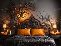 a bedroom decorated for halloween with pumpkins and trees on the wall, along with candles