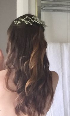 the back of a woman's head in front of a mirror with flowers on it