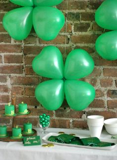 a table topped with lots of green balloons