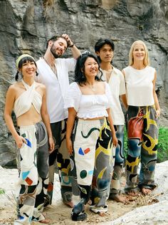 A functional work of art, tailored for you. Each pair of these batik pants is one-of-a-kind! Photos show suggested motifs, but your pair will be uniquely yours. With only 10 pieces made per year, you’ll own something truly exclusive. Size: LargeWaistband: 32" - 46"Inseam: 32.5"Mali (center front) and Adam (in blue Raglan Top) wear size L. Features:- 100% cotton: pre-shrunk, soft, breathable- Elastic waistband for extra comfort & fit- 4 Pockets: 2 deep front, 2 back- Secret pocket: fits cards, ca Hand Painted Clothes, Batik Pants, Unique Pants, Unique Photos, Tropical Prints, Secret Pocket, Raglan Top, Batik Dress, Painted Clothes