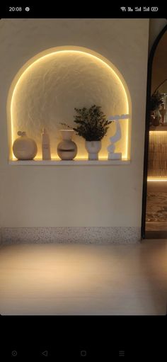 a white vase sitting on top of a counter next to a potted plant