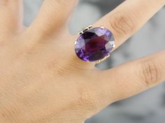 "This is a stunning stone, with a rich color and a sophisticated cut. This natural, well-cut amethyst at the center glimmers with its medium-deep eggplant purple color that flashes with pops of violet and raspberry. We've set this pretty gem into a vintage mounting of yellow gold. Easy to wear, this sits comfortably on the finger and is a nice, bold size that is sure to make a statement! Metal: 14K Yellow Gold Gem: Amethyst 19.50 Carats Gem Measurements: 15.9 x 20.8 mm, Oval Ring Size: 5.50 Mark Oval Stone Ring, Amethyst Cocktail Ring, Right Hand Ring, Right Hand Rings, Hand Ring, Eggplant Purple, Oval Ring, Oval Rings, Oval Stone