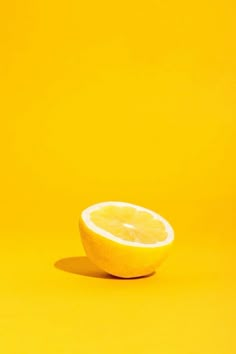 a half eaten lemon on a yellow background