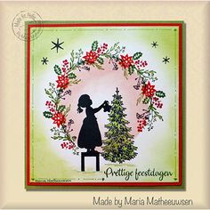 a card with a silhouette of a girl holding a christmas tree in front of a wreath