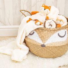 a basket filled with stuffed animals sitting on top of a white rug