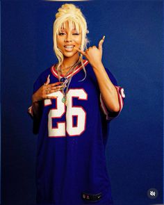 a woman in a football uniform posing for the camera with her hand on her hip