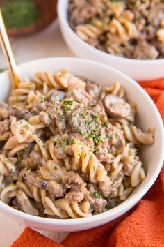 two white bowls filled with pasta and meat