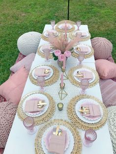 the table is set with pink and gold plates