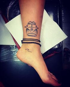 a woman's foot with a tattoo on it and a bus in the background