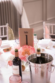 the table is set with wine bottles and glasses