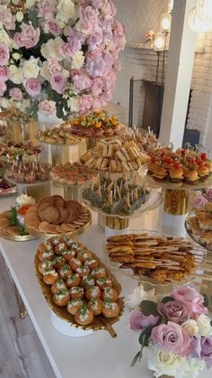 a table topped with lots of desserts and pastries on top of white plates