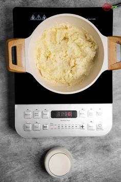 a bowl of mashed potatoes sitting on top of a stove