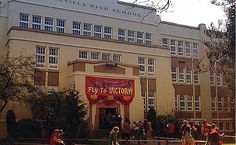 people are walking in front of a school building