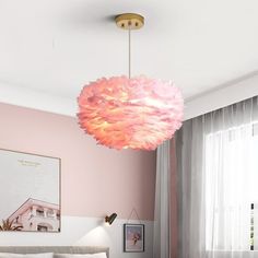 a bedroom with pink walls, white bedding and a chandelier hanging from the ceiling