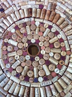 a wine cork table with many different types of wine bottles on it and a hole in the middle