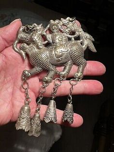 a person is holding some silver items in their hand and it looks like they have been made out of metal