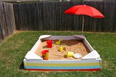 a sandbox with an umbrella and toys in it