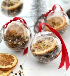 three glass ornaments with orange slices in them