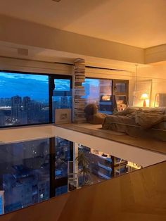 a bedroom with a large window overlooking the city at night and lit up by lamps