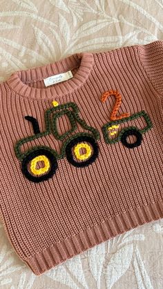 a sweater with a tractor embroidered on it