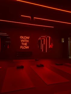 a red room with yoga mats and neon lights