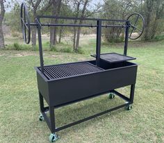 an outdoor grill on wheels in the grass