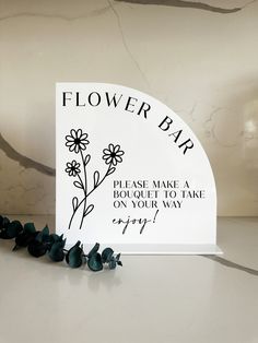 a flower bar sign sitting on top of a table