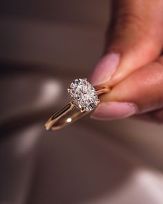 a close up of a person holding a diamond ring