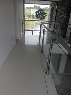 an empty hallway with glass railings leading to the outside