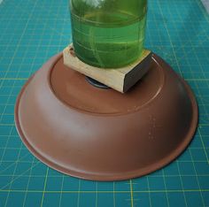 a green drink sitting on top of a wooden coaster