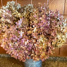 a vase filled with lots of purple flowers