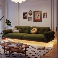 a living room with green couches and pictures on the wall above them, along with a coffee table