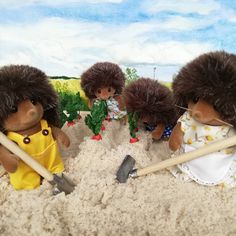 four toy hedgehogs are digging in the sand