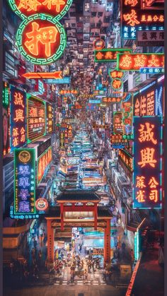 an image of a city street at night with lots of neon signs on the buildings